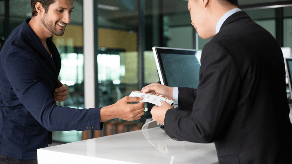 businessman handing plane ticket and passport to employee