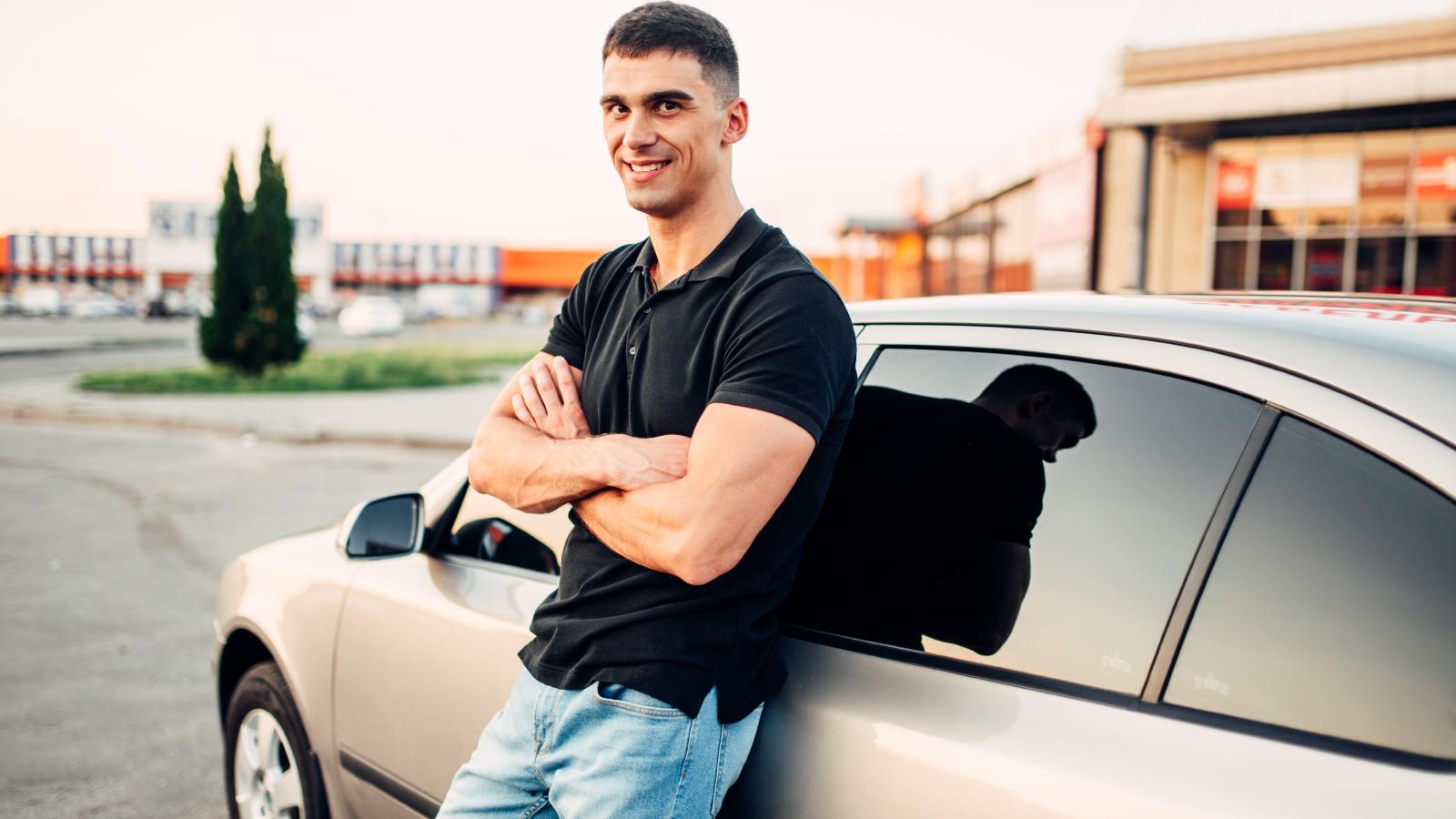 His Old Boss Always Gave Him a Hard Time About Smoking—Now He Makes a Point of Lighting Up in Front of Him man leaning against a car