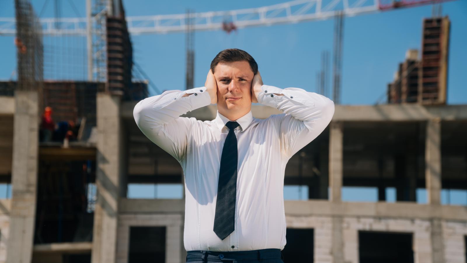 His Neighbors Are Building a Warehouse Without Permits—But He’s Hesitant to Report Them Because They’re Felons man covering his ears