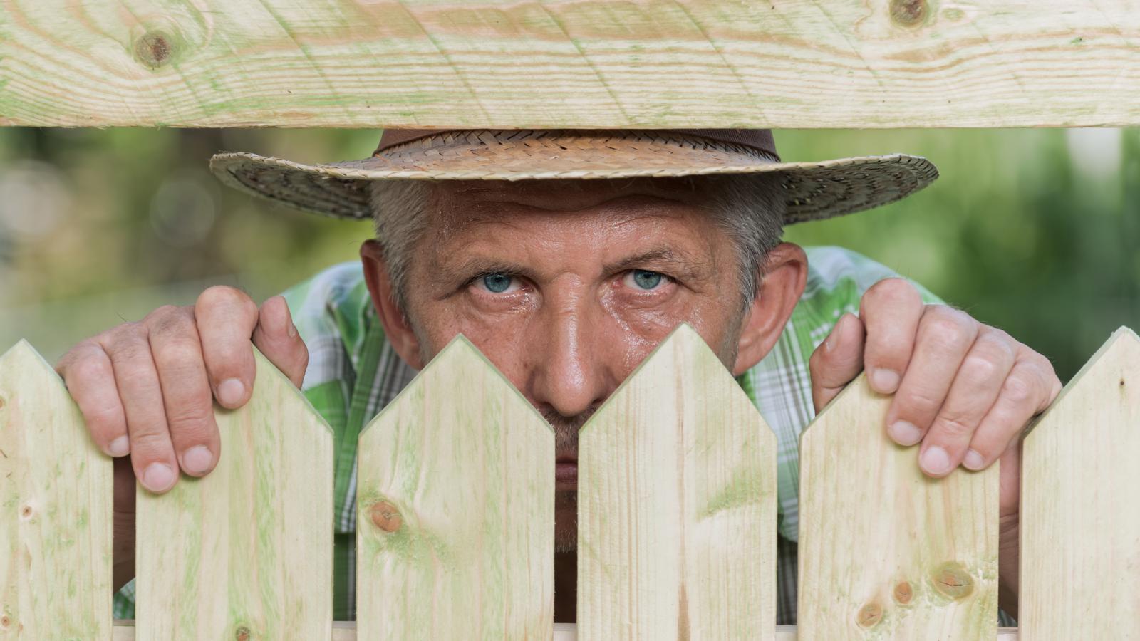 man looking through a fence