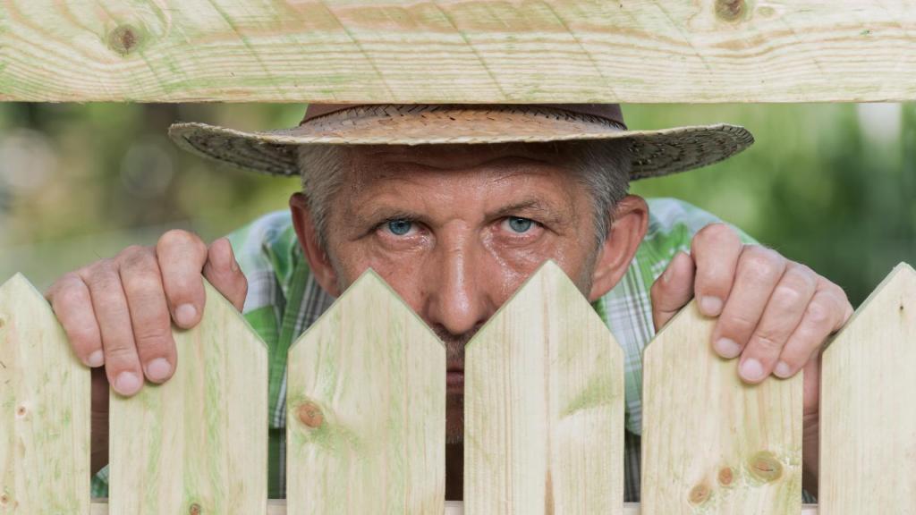 man looking through a fence