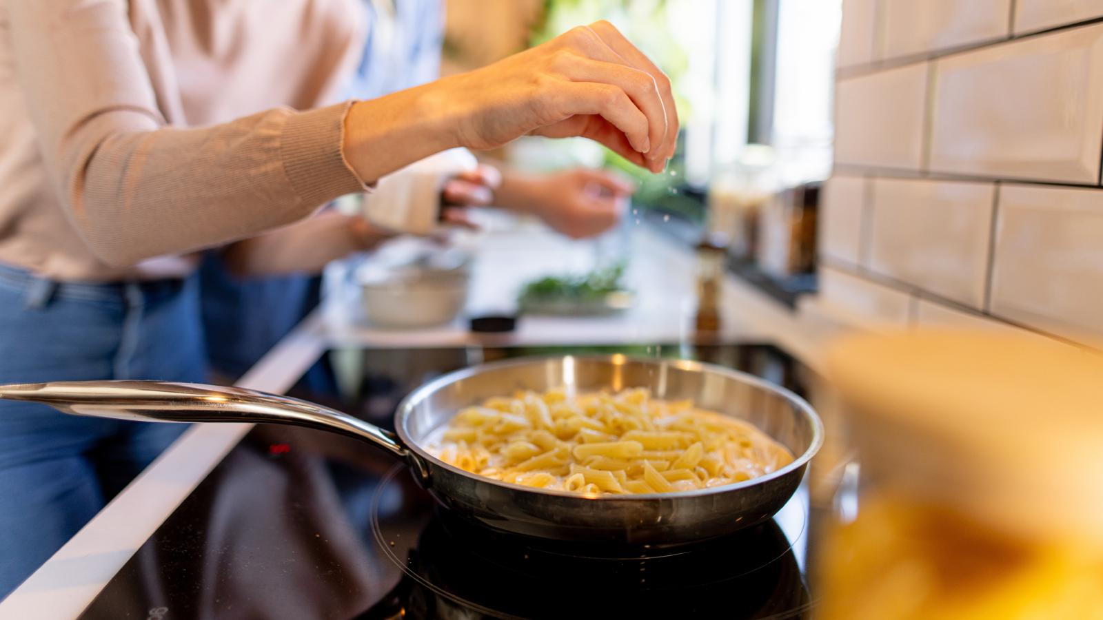 She Didnt Think to Save the Pasta Water. Her Roommates Reaction Made Her Feel Like Shed Committed a Real Offense woman preparing some pasta