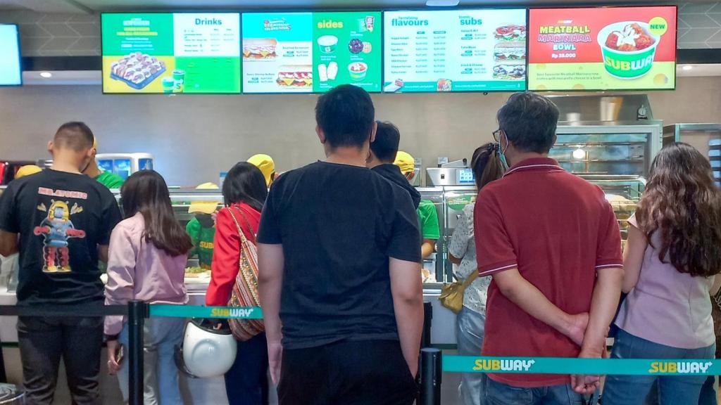 people in line at a sandwich shop