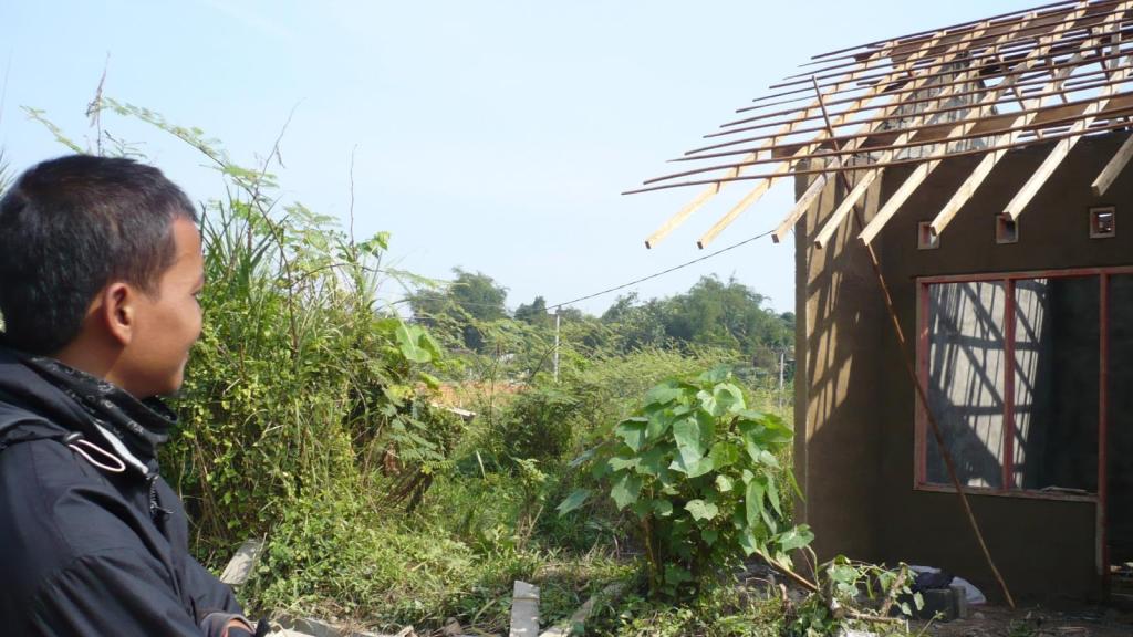 man looking at a house under construction