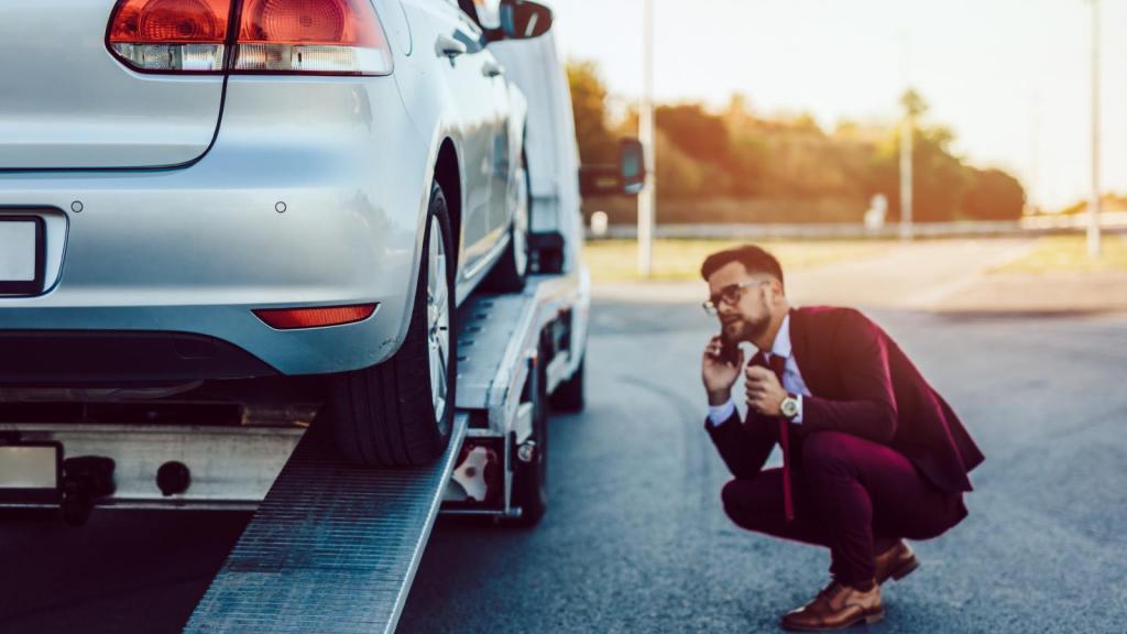 man next to a towed car