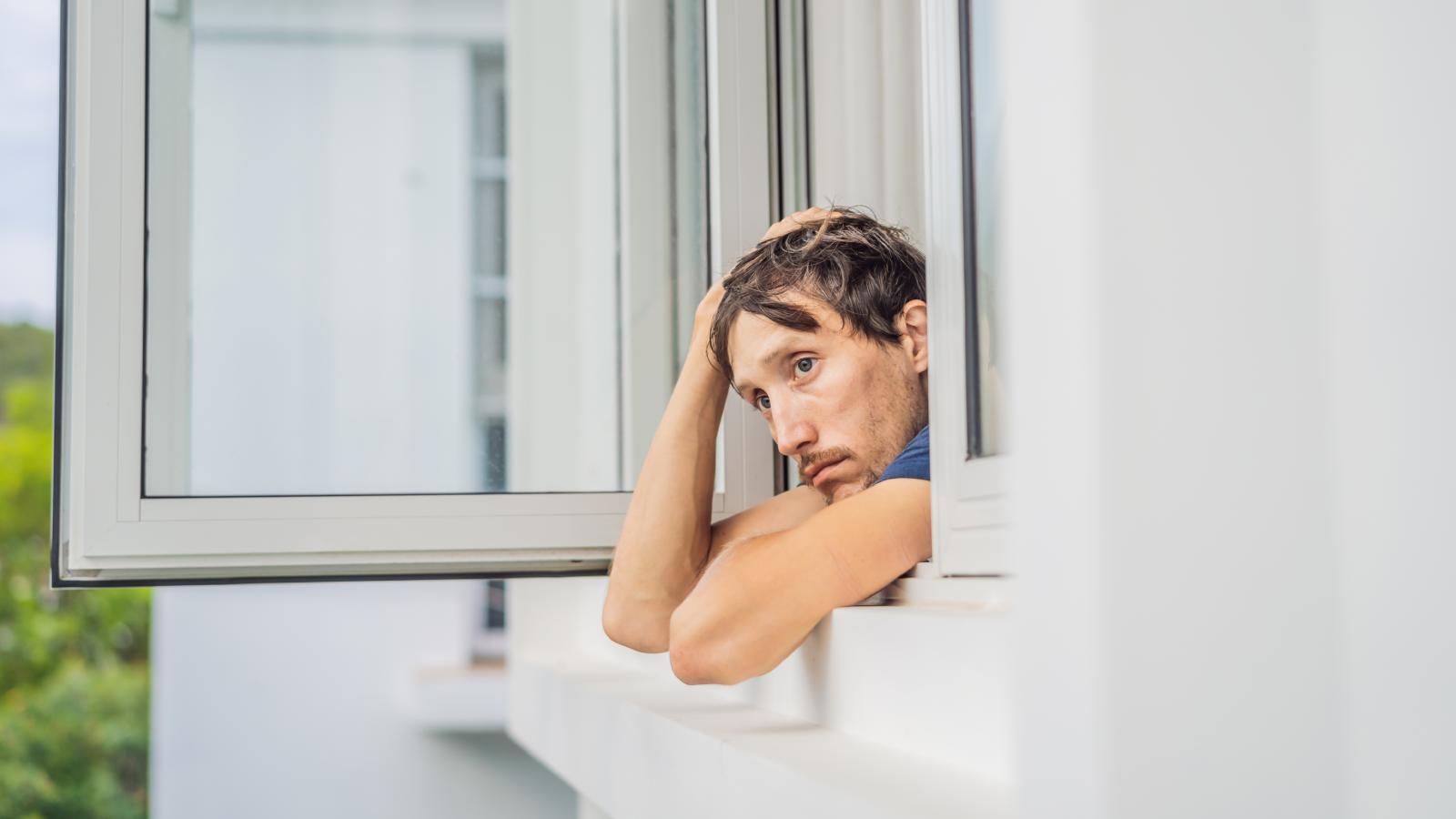 Their Quiet Neighborhood Is Being Ruined by One Neighbor’s Endless Garage Jam Sessions man looking out a window