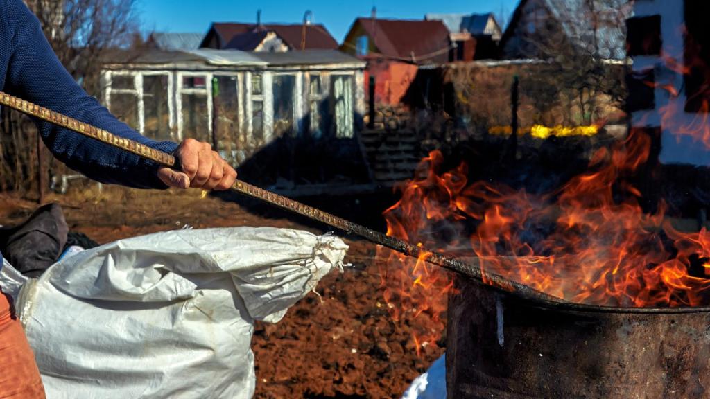 man burning trash in a barrel