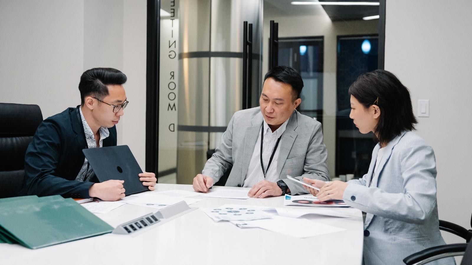 A Boss Promised Him a Secret Bonus—Then HR Accused Him of Making the Whole Thing Up corporate employees sitting in a conference room