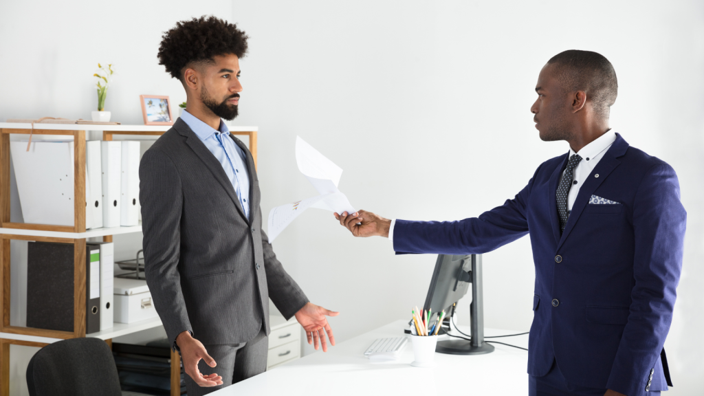 employee handing over paper to boss