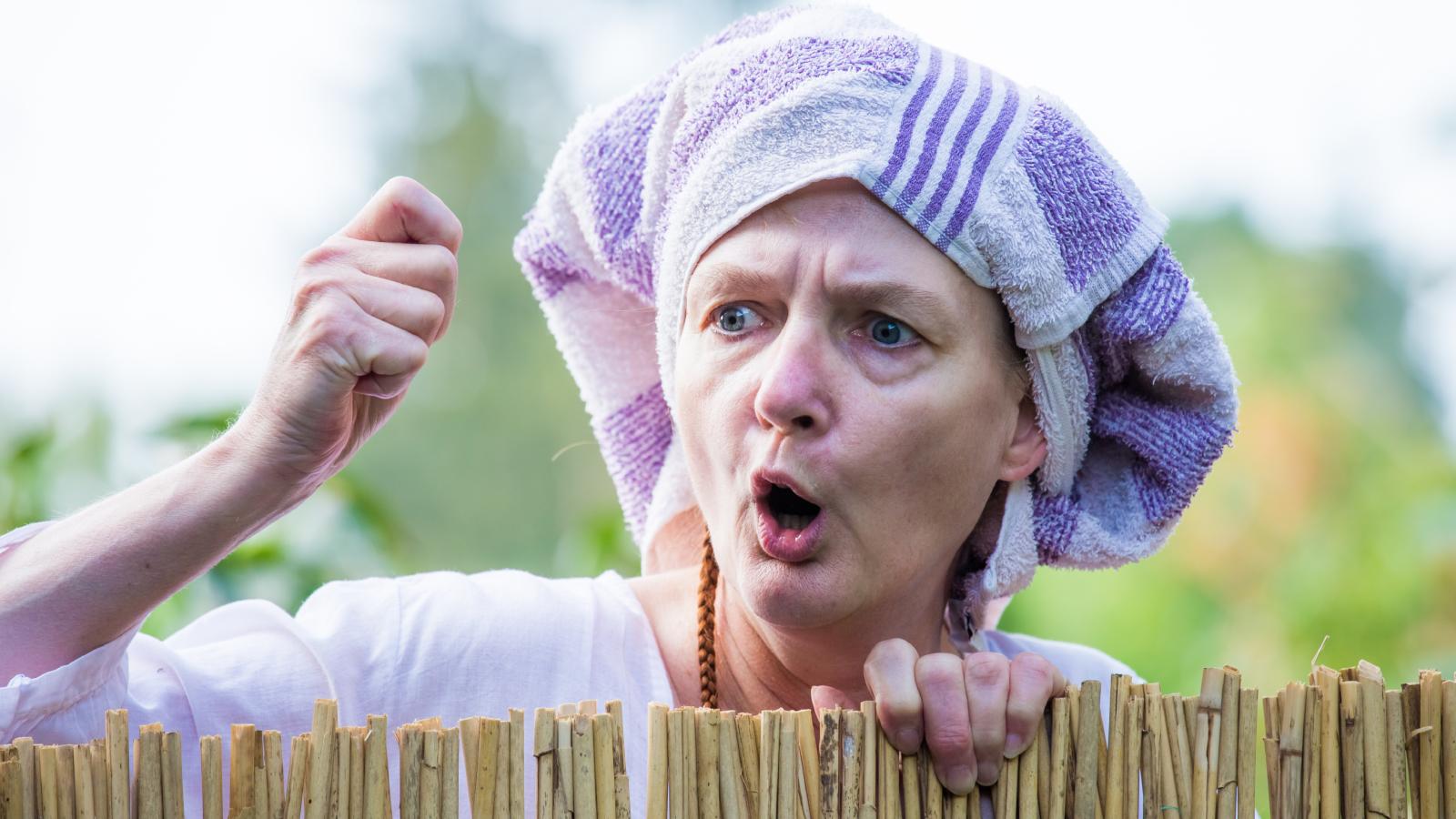 woman yelling over a fence