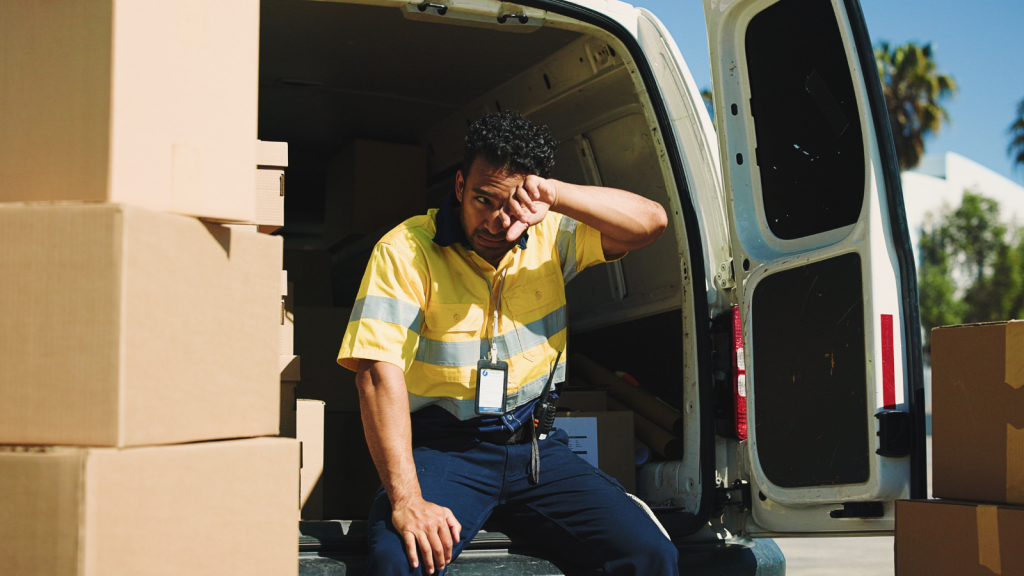 fatigued delivery driver man with boxes