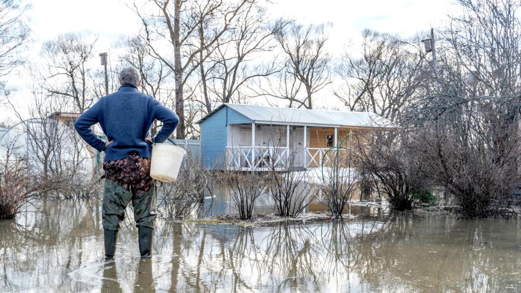 man standing in a flooded yard