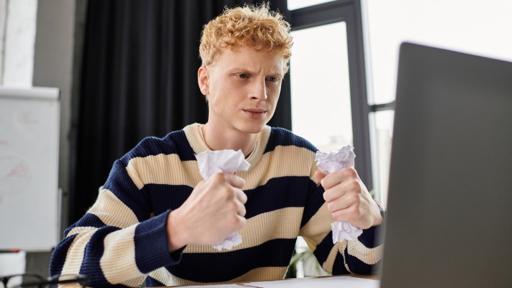 frustrated young man at his desk in office
