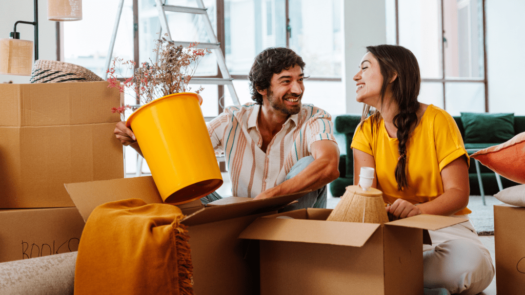 girlfriend and boyfriend packing apartment smiling