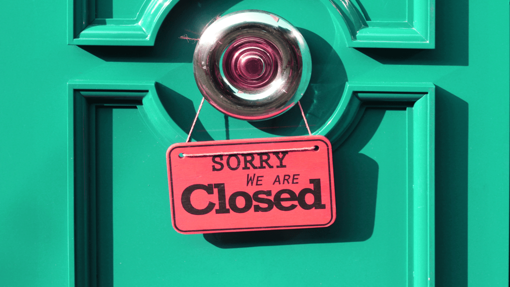 green door with closed sign hanging from doorknob