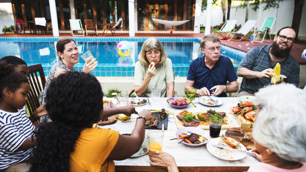 group of people eating outside by pool
