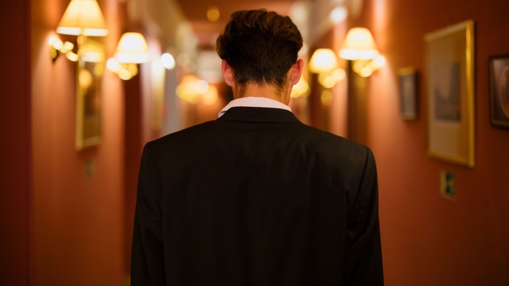 man walking through a ritzy hotel