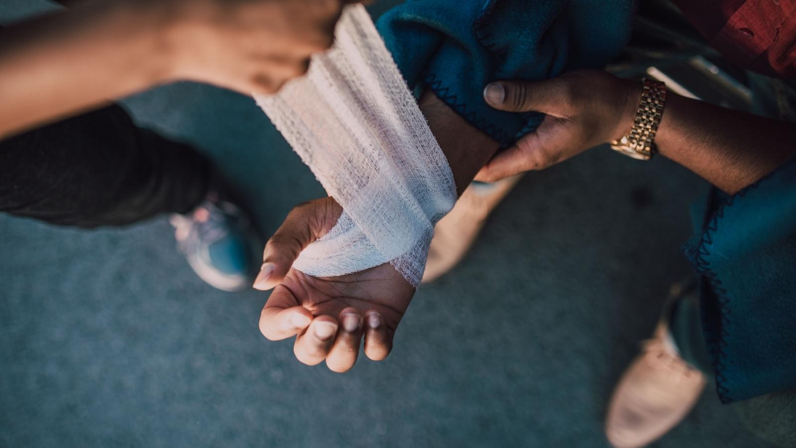 A Pet Hotel Worker Was Bitten by an Aggressive Dog—and Her Boss Blamed Her for Not Reporting It Fast Enough injured woman bandaging her hand