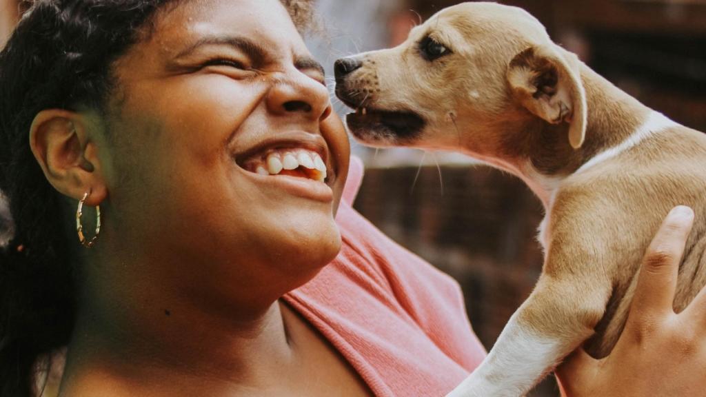 laughing woman holding a puppy
