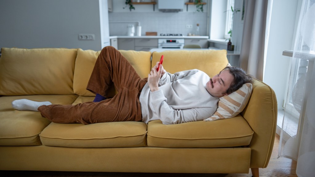 lazy bored man lying on sofa
