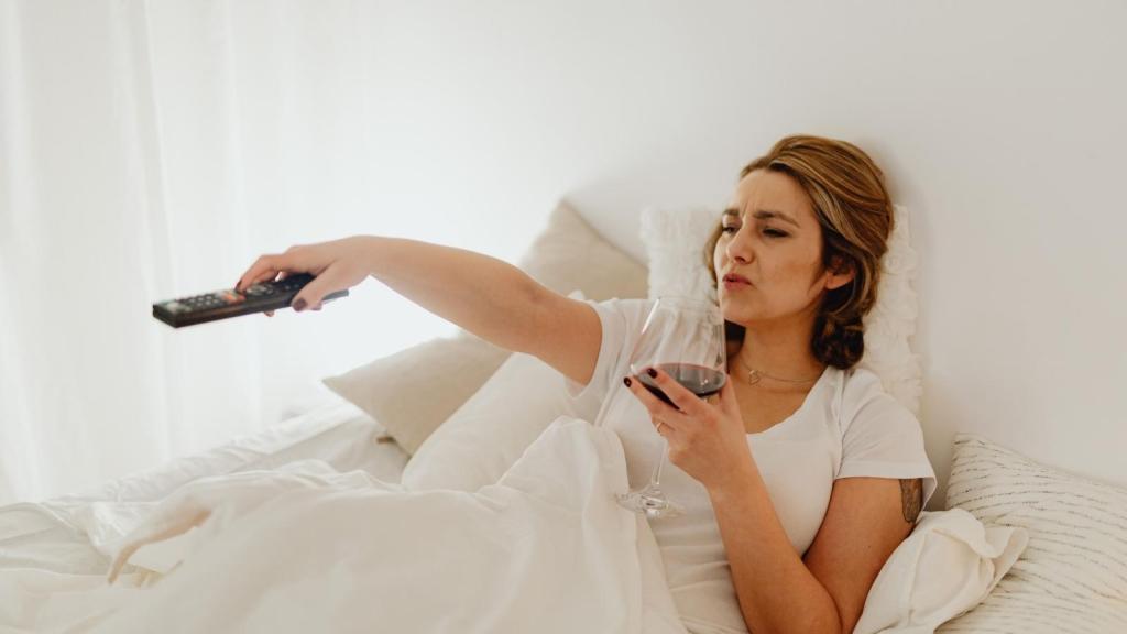 lazy woman watching tv in bed