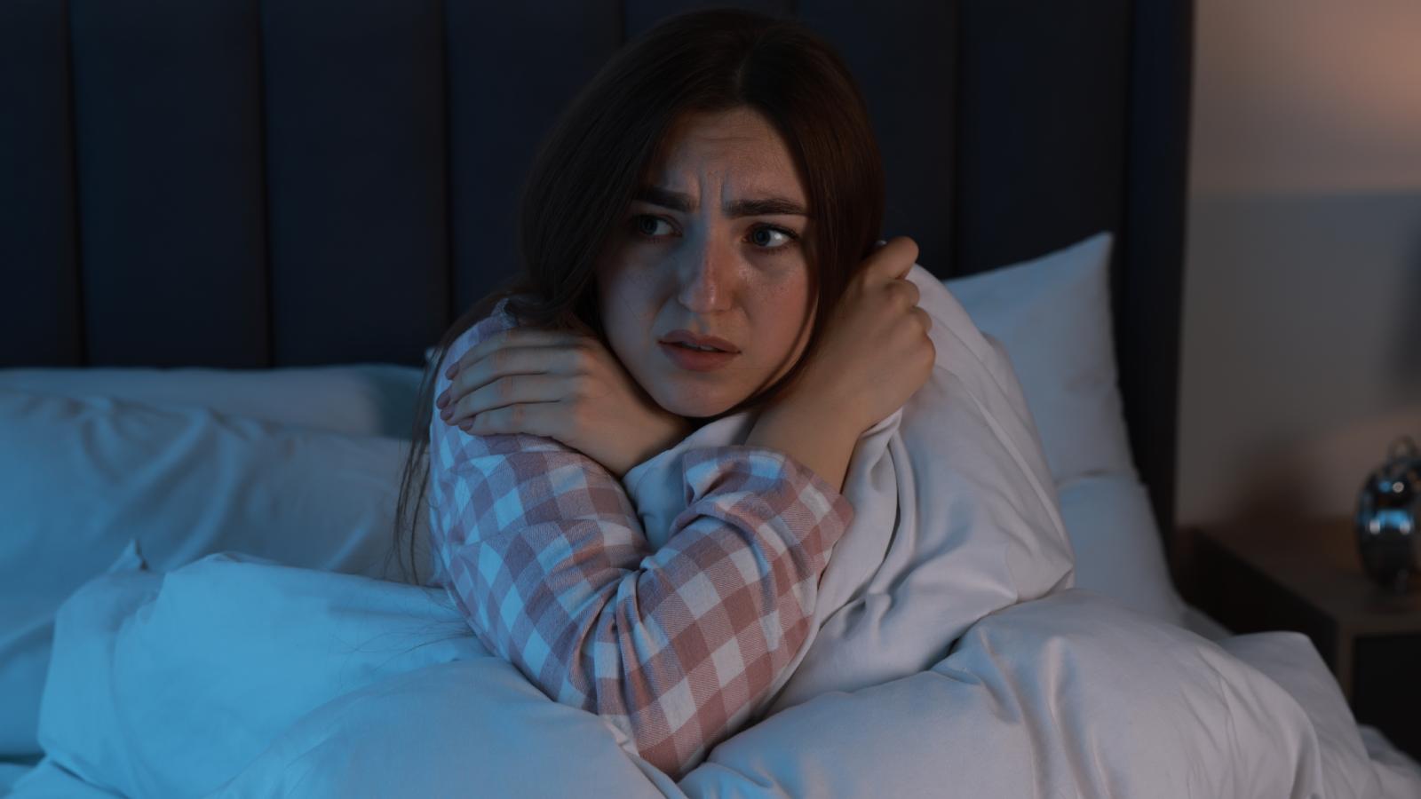 woman scared in her bed