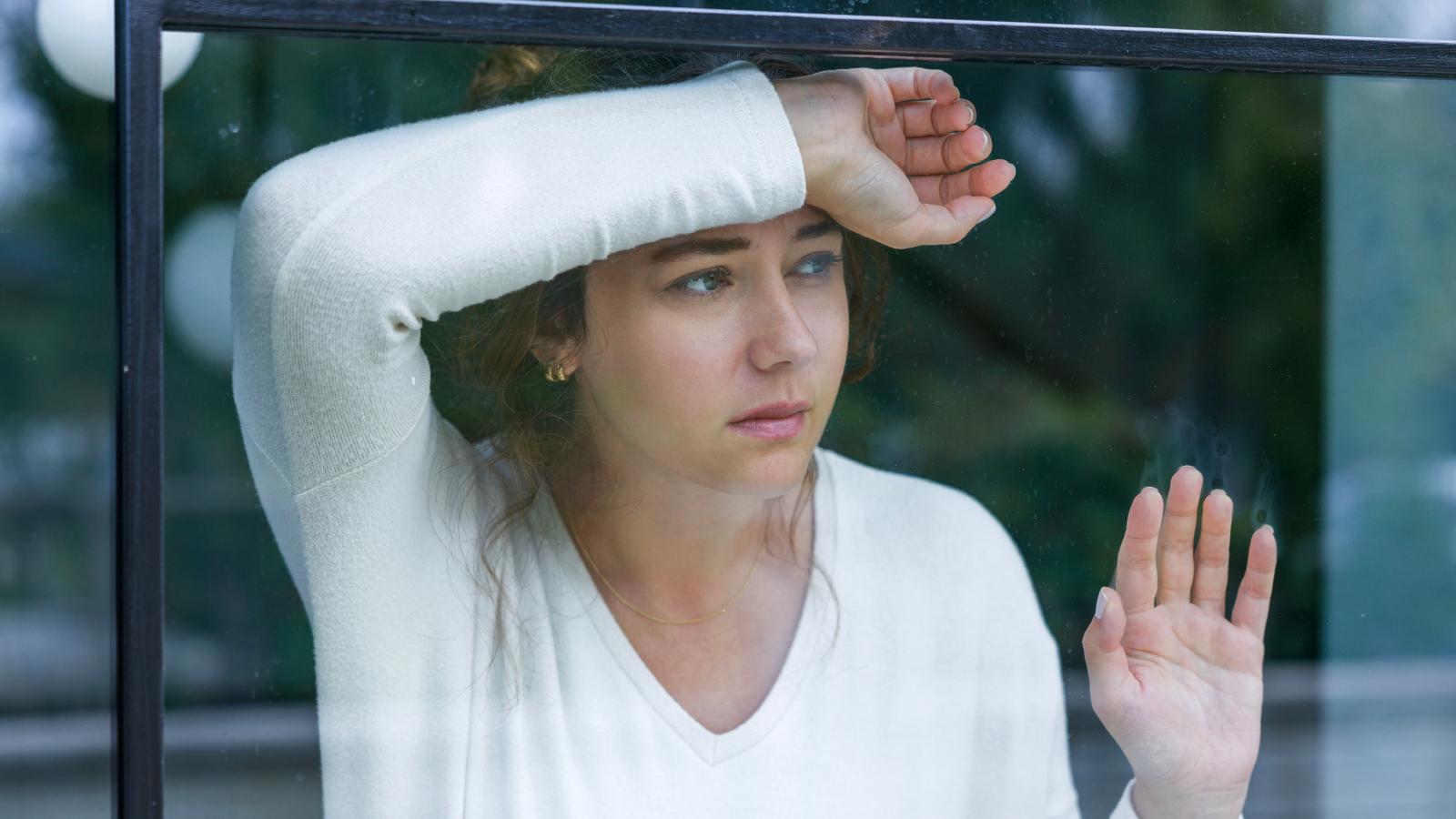 Homeless Encampment Set Up Right Against Her Backyard Fence—Now She Can’t Even Let Her Dogs Outside woman looking out a window