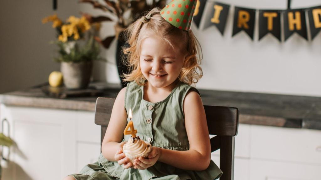 little girl holding cupcake on her birthday