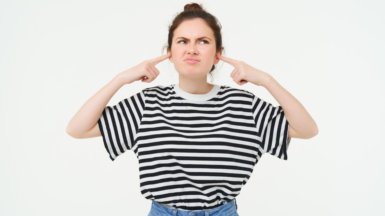 Her Neighbors’ Music Is So Loud She Can Hear It Throughout Her Home—Now She’s Had Enough woman plugging her ears