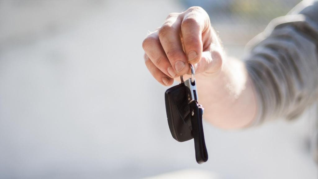 man holding up car keys