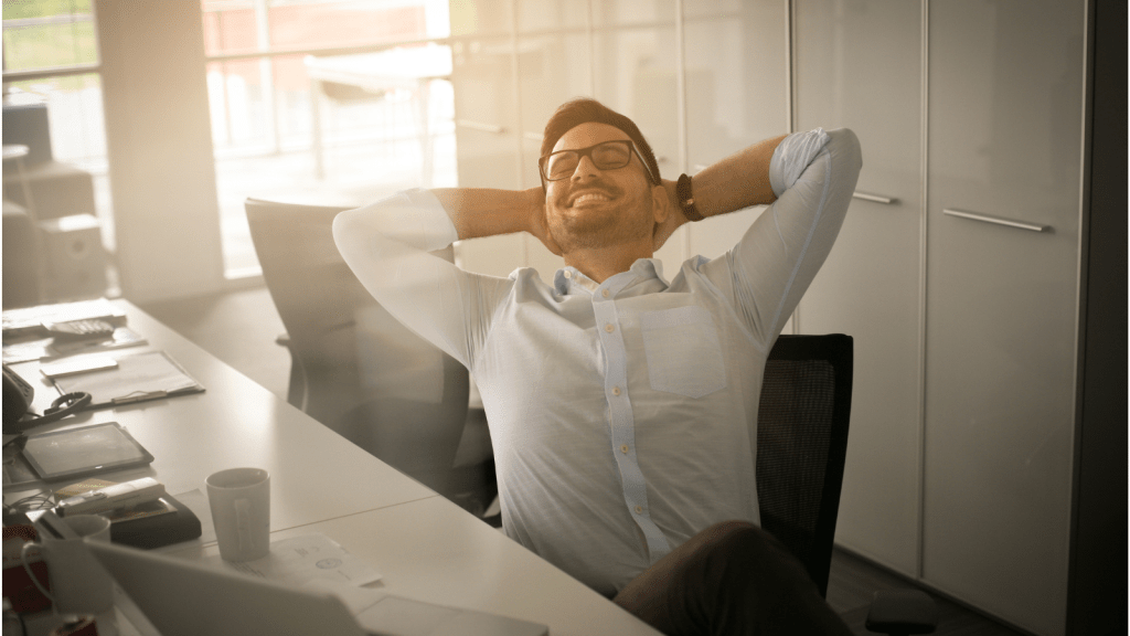 man in office smiling to himself at cubicle