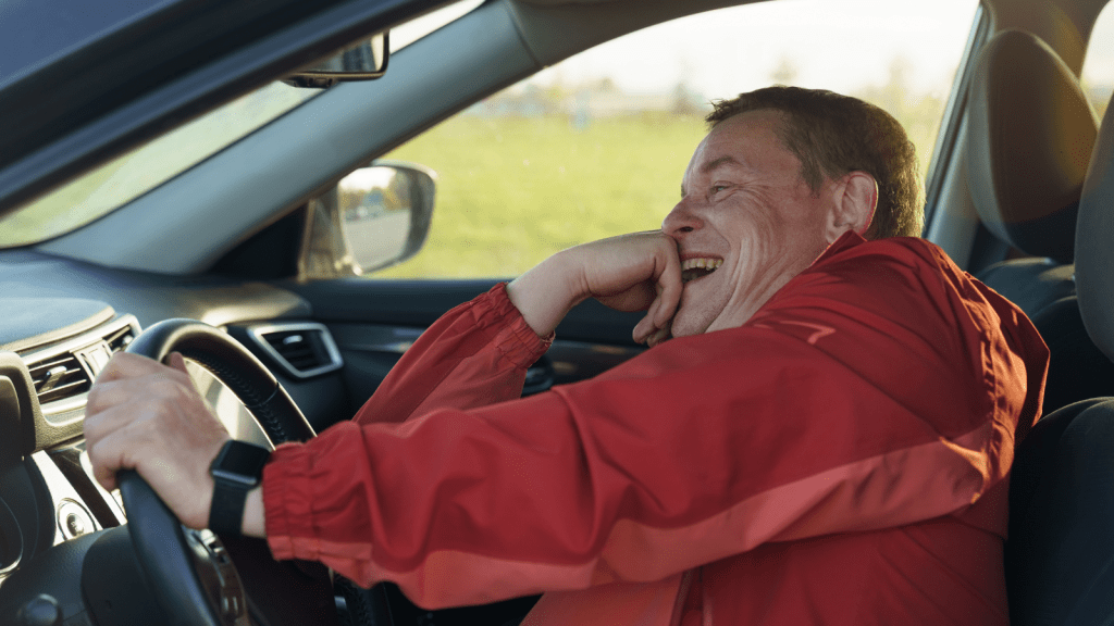 man laughing hysterically while driving