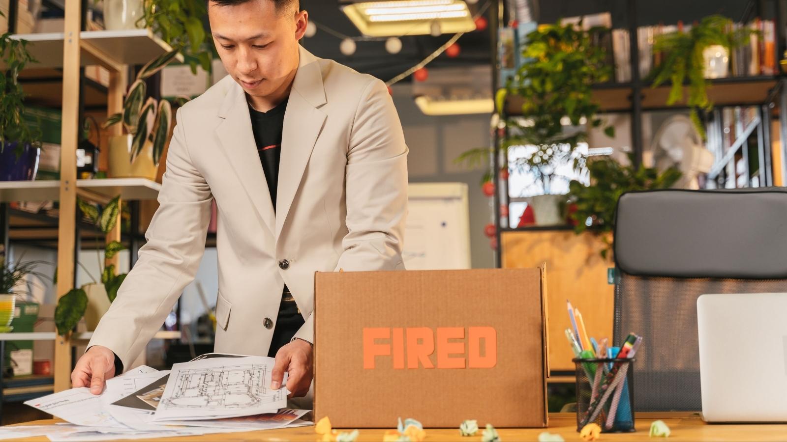 man packing up a box that says fired