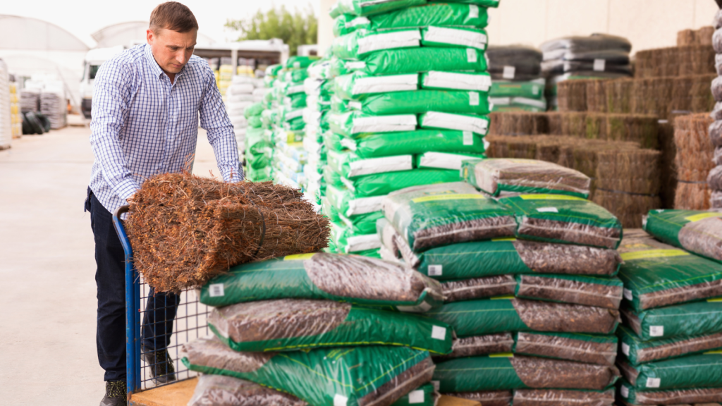 man placing soil mulch on cart