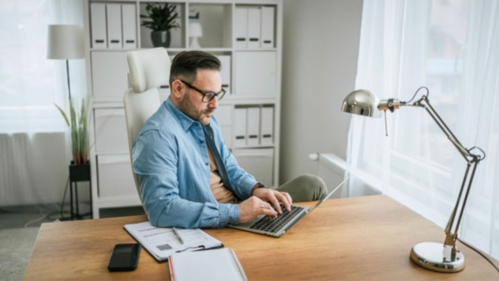 businessman at laptop working wearing glasses