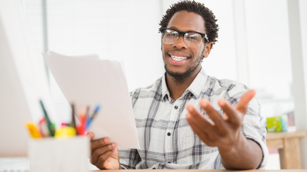 man with paper smiling at work