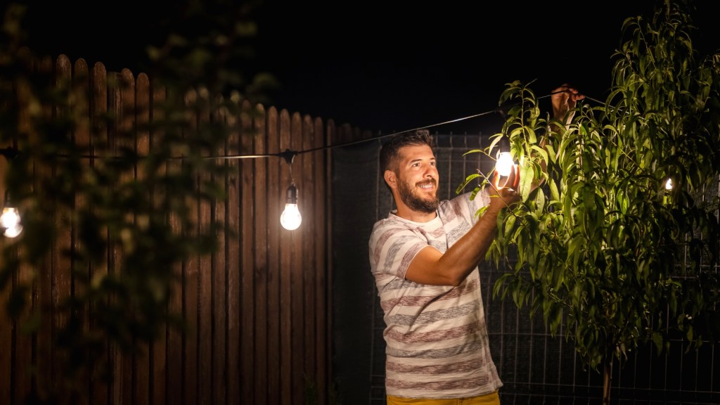man with yard lights at night