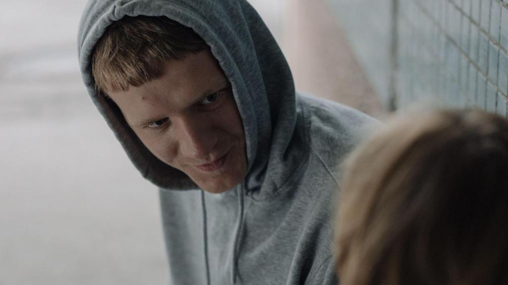 mischievous teen in gray hoodie