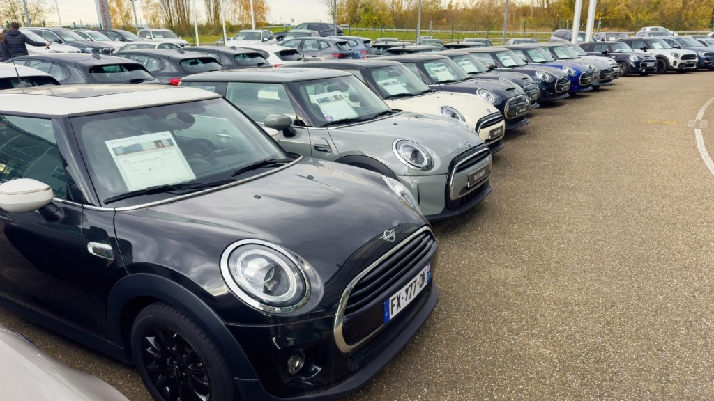 new cars on lot with stickers in windshields