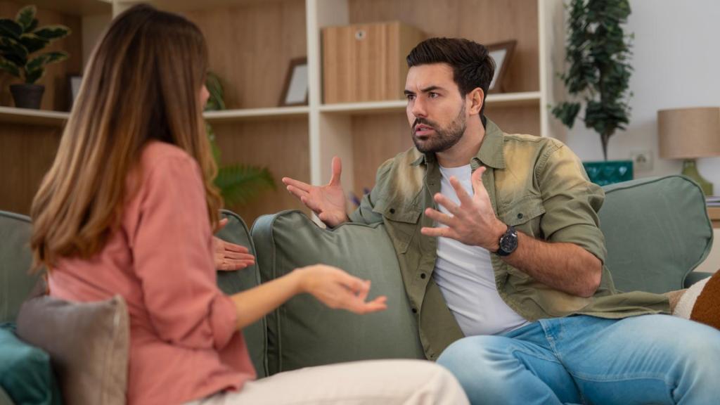 man and wife arguing on couch