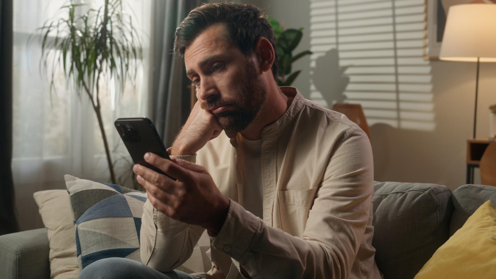 A Company Dragged Him Through 8 Round Job Interviews—Then Completely Ghosted Him After the Final Interview man looking at his phone