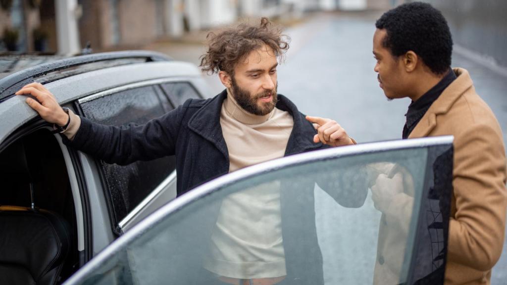 two men talking by a car