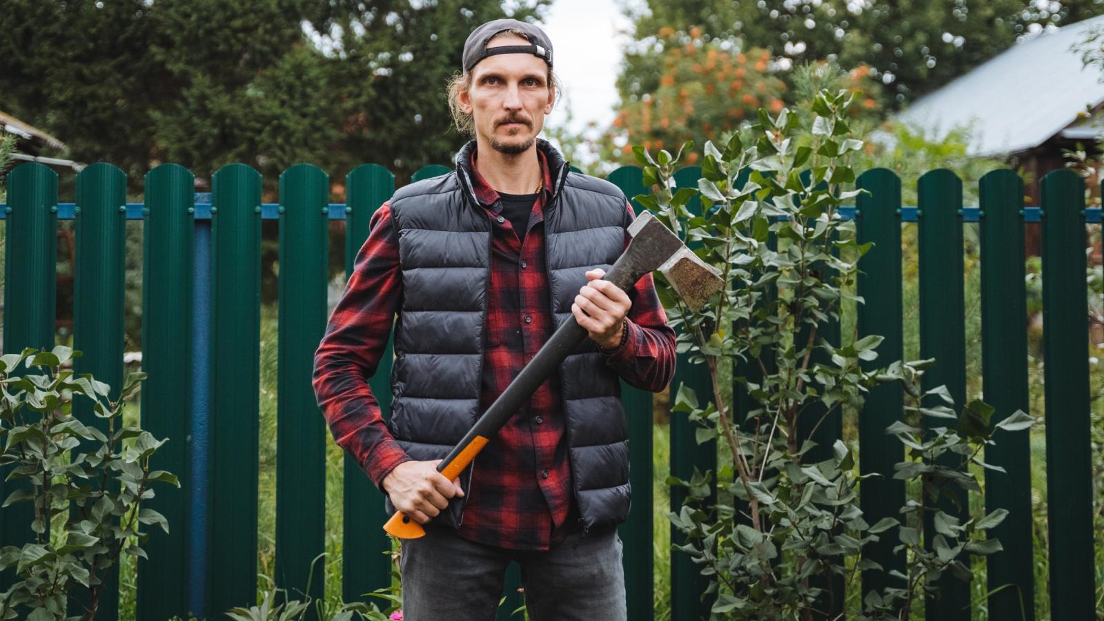 His Neighbor Built a Fence on His Property—So He Tore It Down Without Hesitation man holding an axe