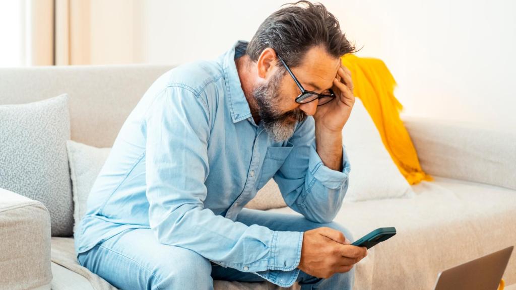 man worried looking at phone