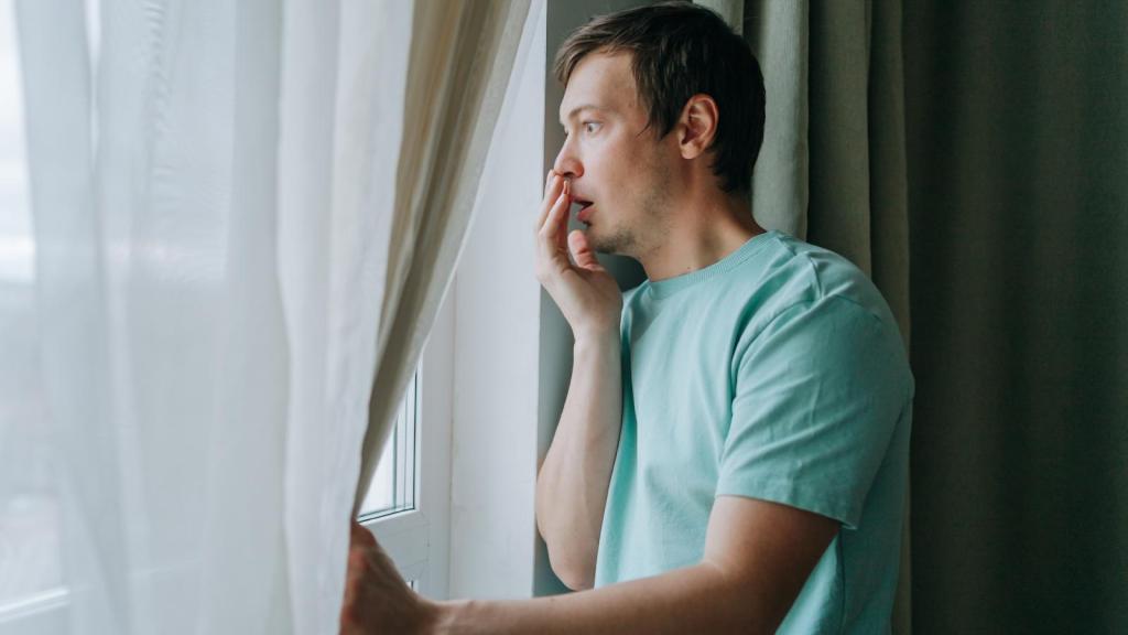 man looking out a window