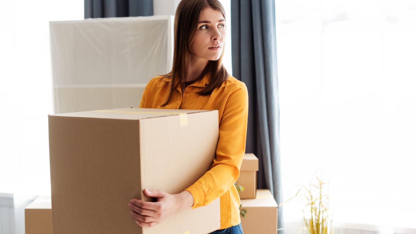 Years of Mistreatment From Her Parents Finally Push Woman to Leave Town and Start Over woman holding a moving box