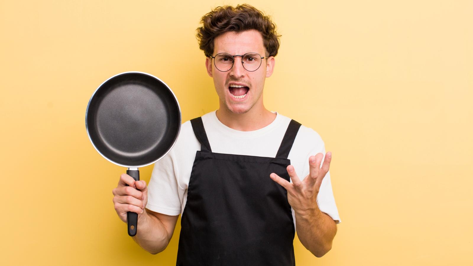 He Just Wanted to Drink Water at Work—So Why Did His Manager Send Him to the Break Room? man holding a skillet
