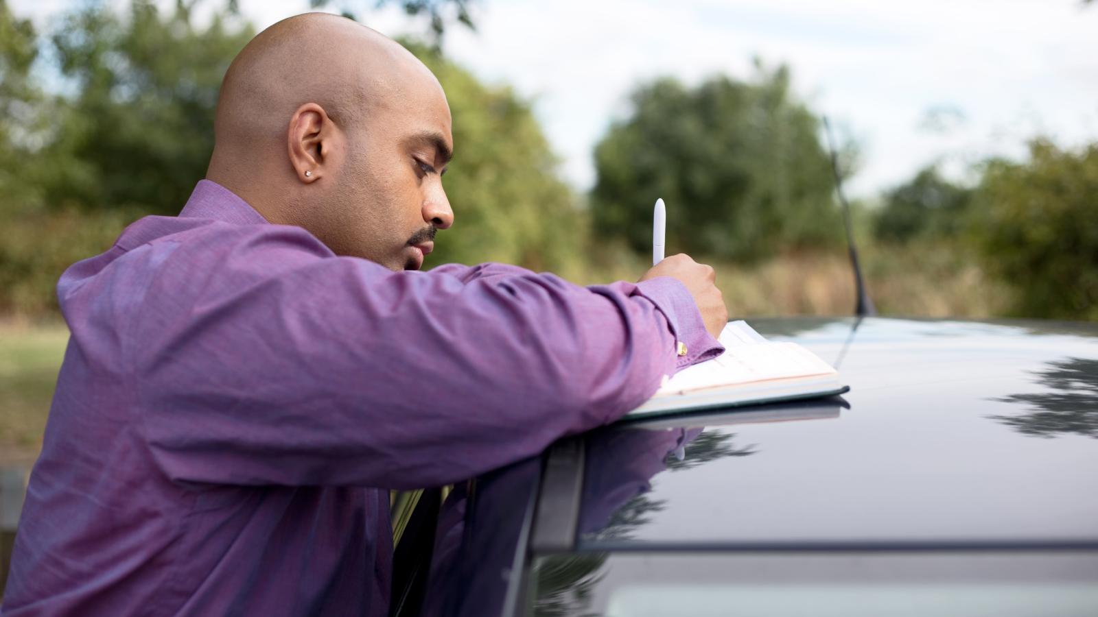 His Neighbor Was Rude About a Parking Note — So He Reported Her Illegal Airbnb man writing a note on a car