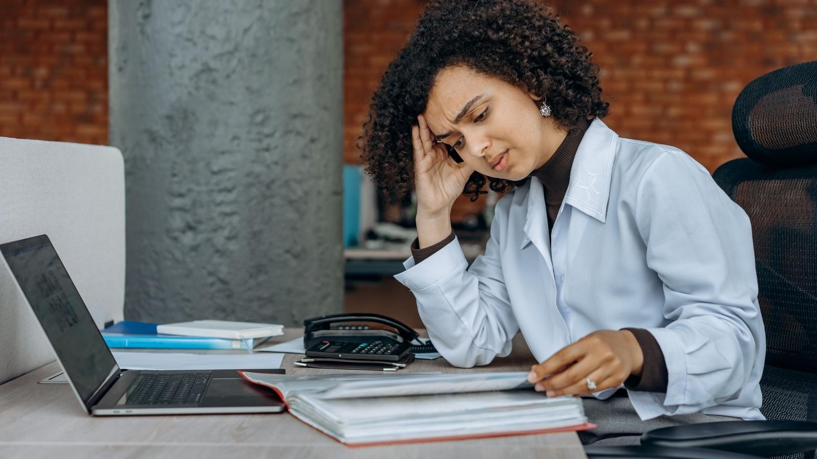 overworked woman sitting at her desk