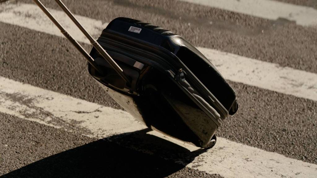 person rolling a suitcase